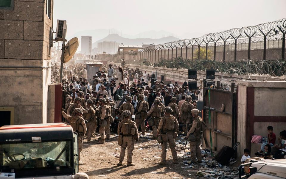 U.S. Marines with Special Purpose Marine Air-Ground Task Force - Crisis Response - Central Command, provide assistance at an evacuation control checkpoint during an evacuation at Hamid Karzai International Airport in Kabul, Afghanistan - Staff Sgt. Victor Mancilla/US Marine Corps via AP