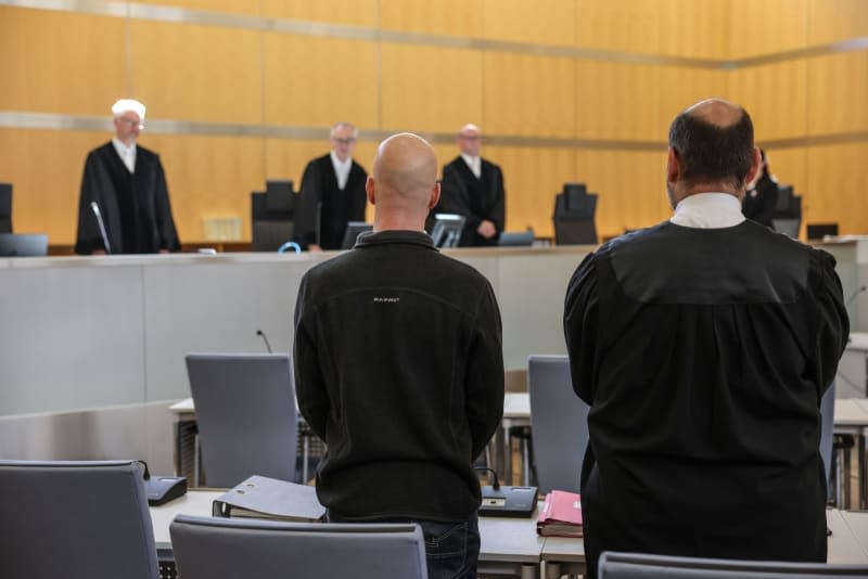 The defendant (L, front) stands next to his lawyer Marvin Schroth (R) in the courtroom of Duesseldorf Higher Regional Court. German prosecutors called on Tuesday for a jail sentence of three and a half years to be imposed on an officer in the German military with far-right political leanings who has confessed to spying for Russia. Oliver Berg/dpa