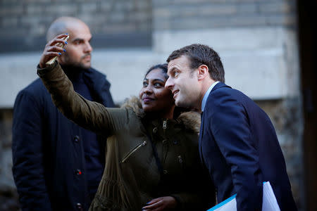 Emmanuel Macron, head of the political movement En Marche !, or Onwards !, and candidate for the 2017 presidential election, poses for a selfie as he leaves his home in Paris, France, May 2, 2017. REUTERS/Benoit Tessier