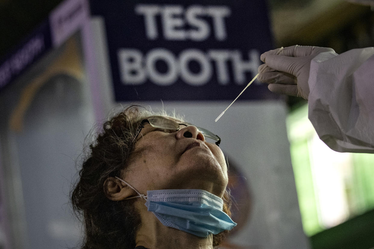 A medical worker conducts a COVID-19 swab test on a resident at a basketball court on August 6, 2020 in Navotas City, Metro Manila, Philippines. (Photo by Ezra Acayan/Getty Images)