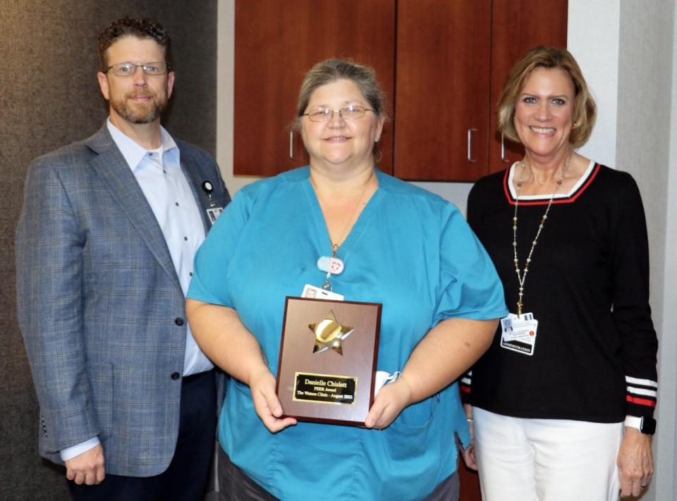 Danielle Chislett, LPN, (middle) displays her PEER Award plaque next to Watson Clinic Chief Administrative Officer Jason Hirsbrunner (right) and Senior Associate Administrator of Human Resources Kelly Lonsberry (left).