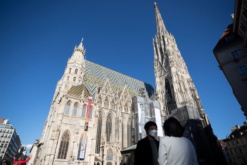 A tourist wears a protective mask in front of St. Stephen's Cathedral in Vienna