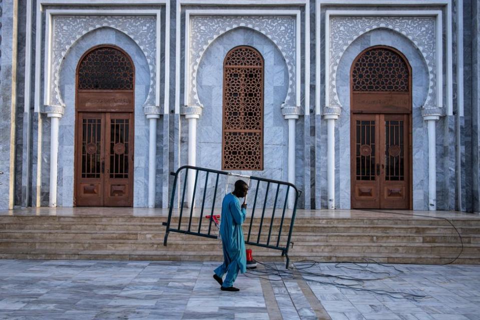 A man carries a barrier at the Massalikoul Djinane Mosque in Dakar.