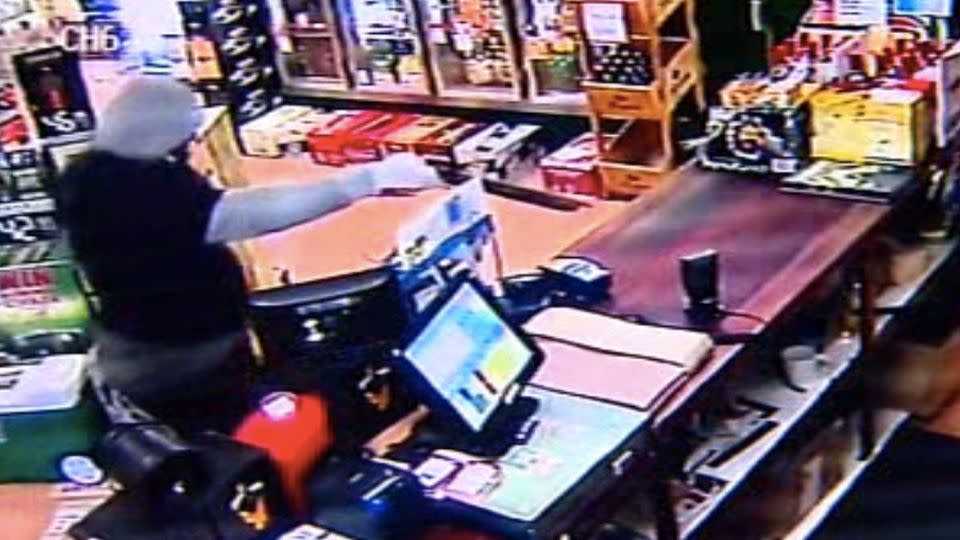 The armed assailant enters one shop armed with a gun. Photo: CCTV