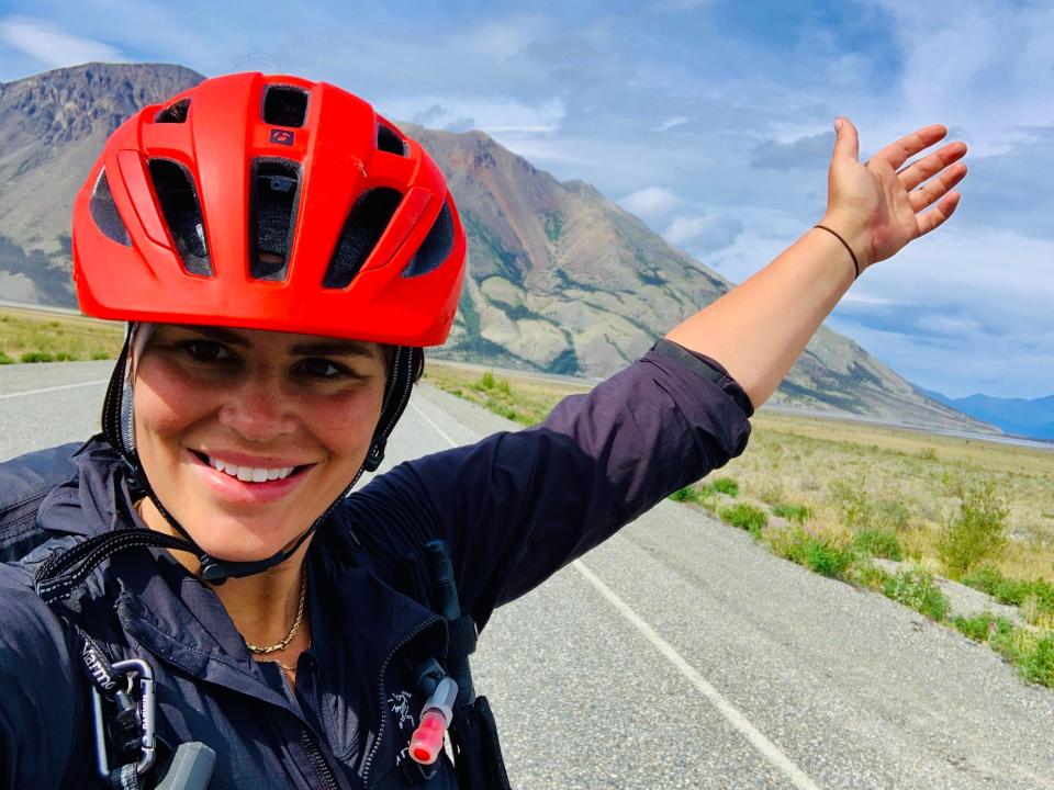 hilarly taking a selfie in a bike helmet in front of a stretch of road in beaver creek canada