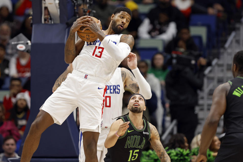 Los Angeles Clippers forward Paul George (13) grabs a rebound in front of New Orleans Pelicans guard Jose Alvarado (15) in the first half of an NBA basketball game in New Orleans, Friday, Jan. 5, 2024. (AP Photo/Tyler Kaufman)