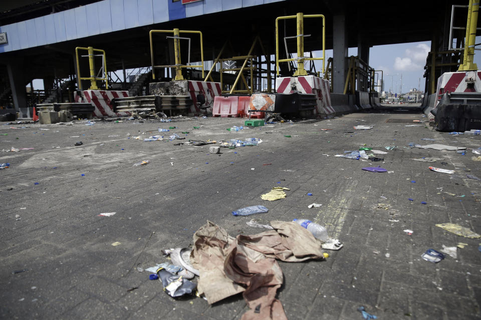 A view of burnt toll gates with anti police slogans sprayed across, in Lagos Friday, Oct. 23, 2020. Resentment lingered with the smell of charred tires Friday as Nigeria's streets were relatively calm after days of protests over police abuses, while authorities gave little acknowledgement to reports of the military killing at least 12 peaceful demonstrators earlier this week. (AP Photo/Sunday Alamba)