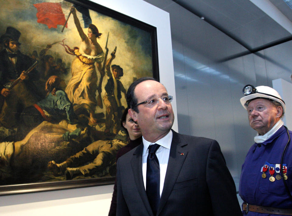 France's President Francois Hollande, center, seen with a former miner, Lucien Laurent, right, in front of " La Liberte Guidant le Peuple", a painting by Eugene Delacroix, during the inauguration of the Louvre Museum in Lens, northern France, Tuesday, Dec. 4, 2012. The museum in Lens is to open on Dec. 12, as part of a strategy to spread art beyond the traditional bastions of culture in Paris to new audiences in the provinces. (AP Photo/Michel Spingler, Pool)