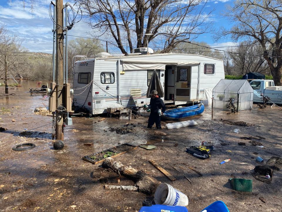 A neighbor takes portable oxygen tanks out of Laura Carris' home on March 22, 2023, after they were forced to evacuate and had to leave them behind.