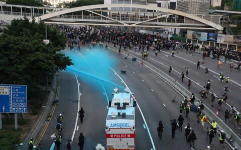 Police spray anti-government protesters with coloured water - Credit: REUTERS/Athit Perawongmetha