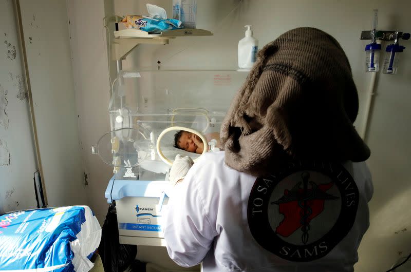 A nurse checks a premature baby at a maternity hospital in Idlib