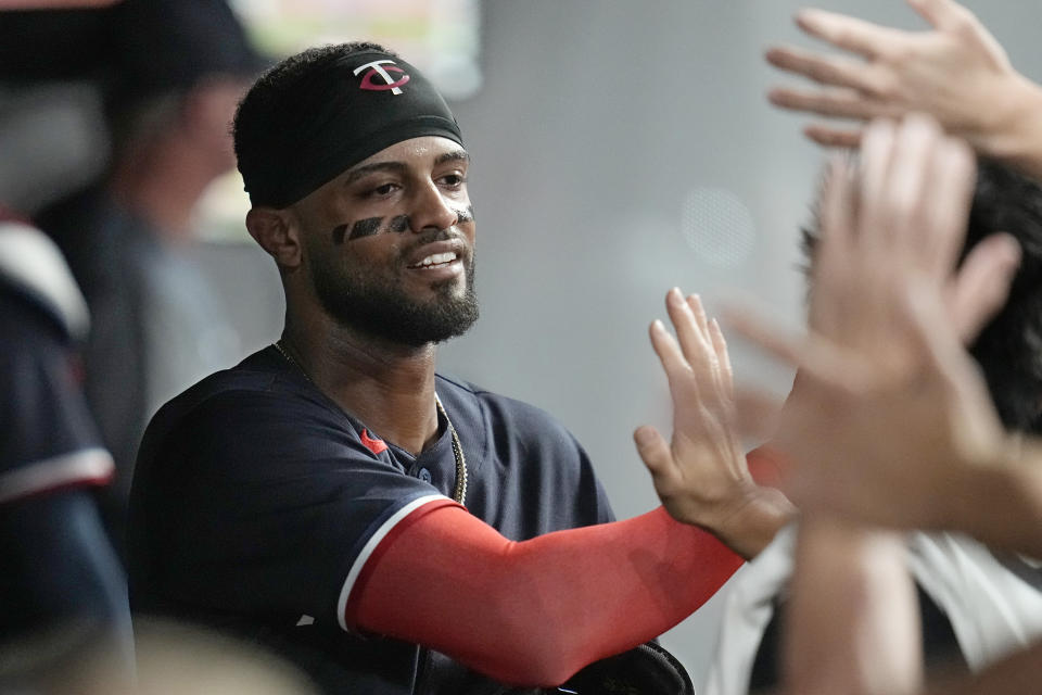 Minnesota Twins' Willi Castro gets high fives in the dugout after scoring on a wild pitch by Cleveland Guardians pitcher Trevor Stephan in the eighth inning of a baseball game Tuesday, Sept. 5, 2023, in Cleveland. (AP Photo/Sue Ogrocki)