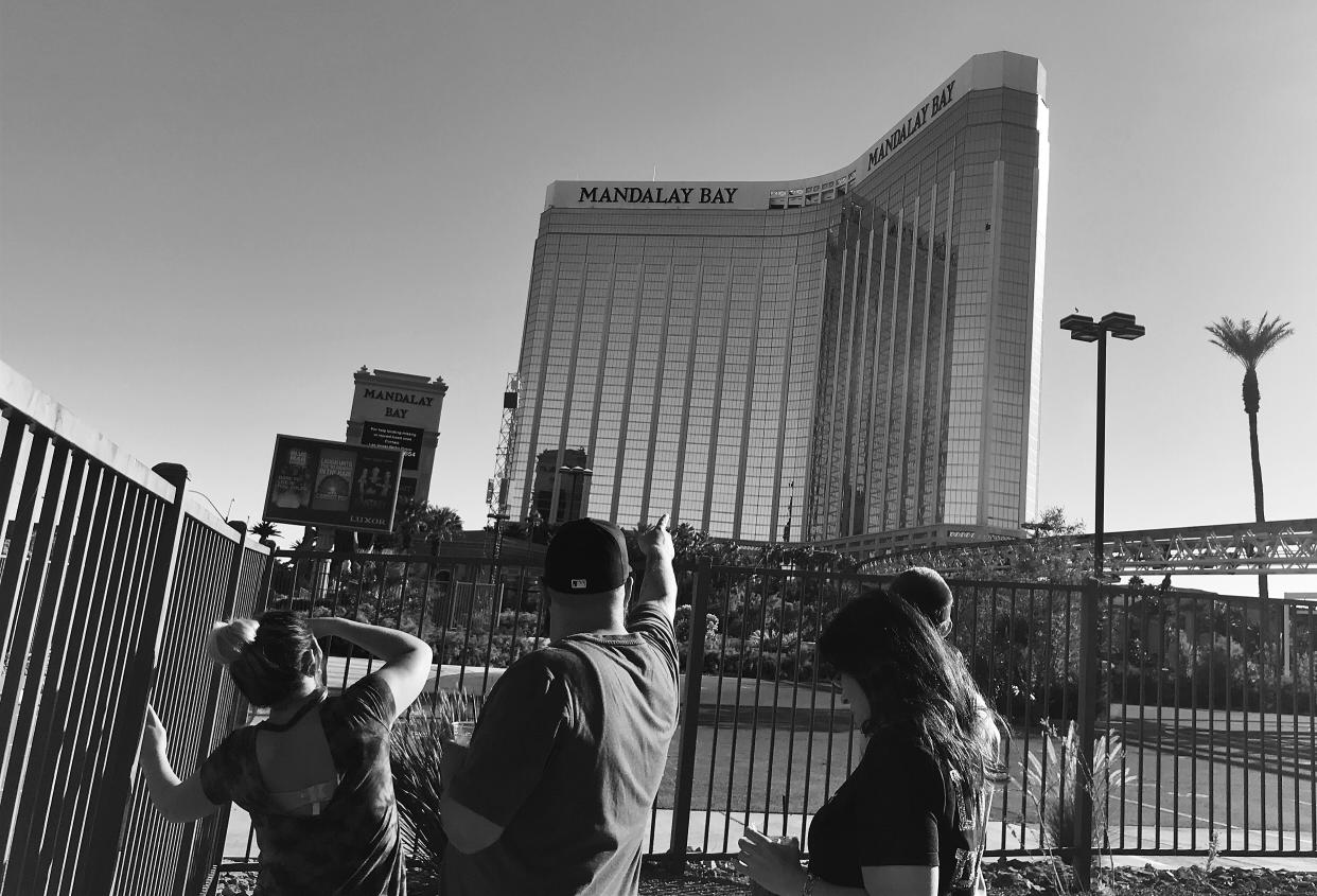 A man points to broken out windows at the Mandalay Bay Resort and Casino Monday where police say accused shooter Stephen Paddock took deadly aim at concertgoers. (Photo: Holly Bailey/Yahoo News)