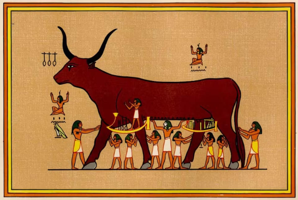 A giant red bull depicted on parchment or ancient cloth is tended to by many skirt-clad, long-haired individuals underneath.