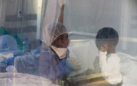 Noella Masika Vinyinyi, 30, an Ebola survivor who works as a caregiver, takes care of Angeline Kalala, 1, who is suspected to be suffering from Ebola - Credit: ZOHRA BENSEMRA&nbsp;/REUTERS