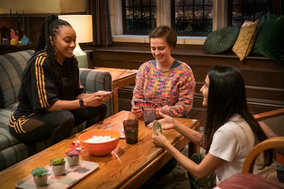 Alyah Chanelle Scott, Pauline Chalamet, Amrit Kaur playing Uno at a table on "The Sex Lives of College Girls."