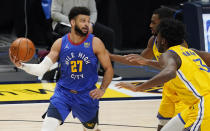 Denver Nuggets guard Jamal Murray, left, looks to pass the ball as Golden State Warriors center James Wiseman, front right, and forward Andrew Wiggins defend in the first half of an NBA basketball game late Thursday, Jan. 14, 2021, in Denver. (AP Photo/David Zalubowski)