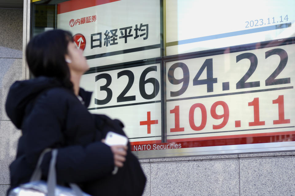 A person walks past an electronic stock board showing Japan's Nikkei 225 index at a securities firm Tuesday, Nov. 14, 2023, in Tokyo. Asian shares were mostly higher Tuesday ahead of potentially market-moving developments, including a U.S.-China summit and data releases from the U.S., Japan and China. (AP Photo/Eugene Hoshiko)