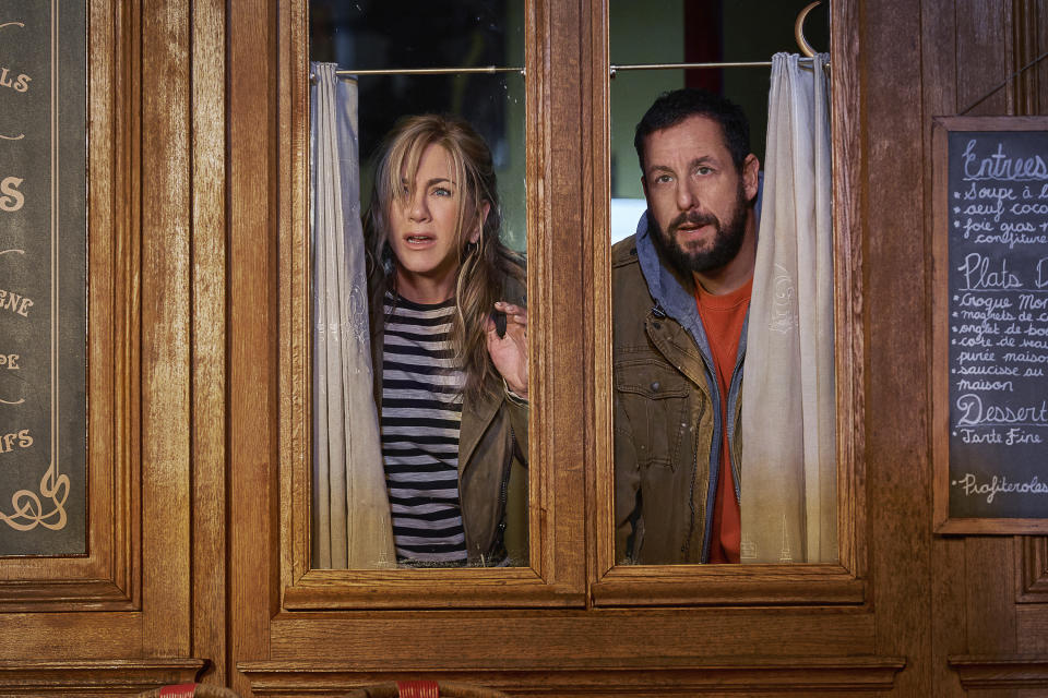 This image released by Netflix shows Jennifer Aniston, left, and Adam Sandler in a scene from the film "Murder Mystery 2." (Scott Yamano/Netflix via AP)