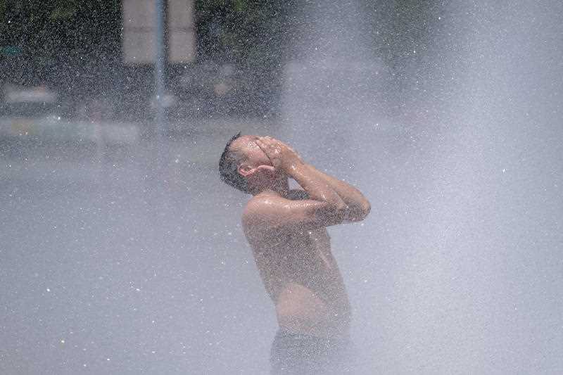 A man cools off in Salmon Street Springs downtown Portland, Oregon.