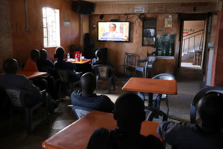 People sitting in a bar in Mathare slum watch Kenyan opposition leader of the National Super Alliance (NASA) coalition Raila Odinga's news conference in Nairobi, Kenya October 31, 2017. REUTERS/Siegfried Modola