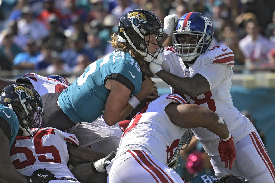 Jacksonville Jaguars quarterback Trevor Lawrence (16) runs into New York Giants linebacker Tae Crowder (48) as he scores on a 1-yard touchdown run during the second half of an NFL football game Sunday, Oct. 23, 2022, in Jacksonville, Fla. (AP Photo/Phelan M. Ebenhack)