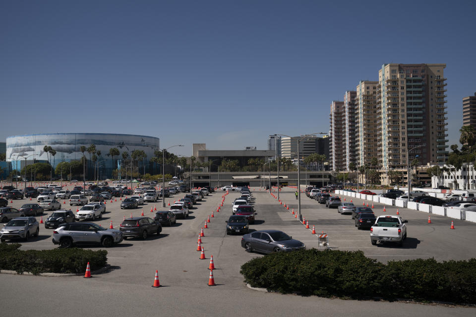 Motorists line up at a COVID-19 vaccination site in Long Beach, Calif., Friday, March 5, 2021. More than 27 million Americans fully vaccinated against the coronavirus will have to keep waiting for guidance from U.S. health officials for what they should and shouldn't do. The Biden administration said Friday it's focused on getting the guidance right and accommodating emerging science. (AP Photo/Jae C. Hong)