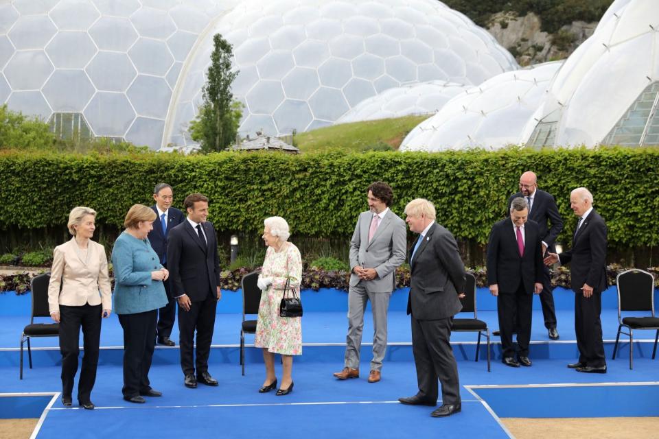 Britain's Queen Elizabeth II (5L), reacts after posing for a family photograph with, from left, President of the European Commission Ursula von der Leyen, Germany's Chancellor Angela Merkel, Japan's Prime Minister Yoshihide Suga, France's President Emmanuel Macron, Canada's Prime Minister Justin Trudeau, Britain's Prime Minister Boris Johnson, Italy's Prime minister Mario Draghi, President of the European Council Charles Michel, and US President Joe Biden during an evening reception at The Eden Project in south west England on June 11, 2021. - G7 leaders from Canada, France, Germany, Italy, Japan, the UK and the United States meet this weekend for the first time in nearly two years, for three-day talks in Carbis Bay, Cornwall. (Photo by JACK HILL / POOL / AFP) (Photo by JACK HILL/POOL/AFP via Getty Images)