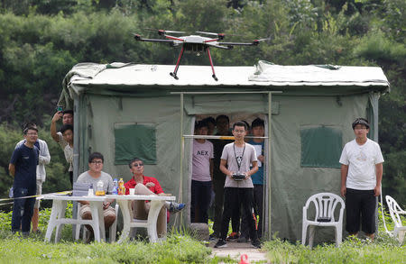 A trainee flies a drone next to a China Civil UAS (Unmanned Aerospace Surveillance) Pilot Flight examiner (in red) during his examination for the license from AOPA CHINA (Aircraft Owners and Pilots Association) at LTFY drone training school on the outskirts of Beijing, China August 14, 2017. Picture taken August 14, 2017. REUTERS/Jason Lee