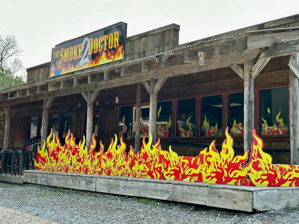 The Smoke 2 Doctor restaurant, a wood building covered in fake red and yellow flames 