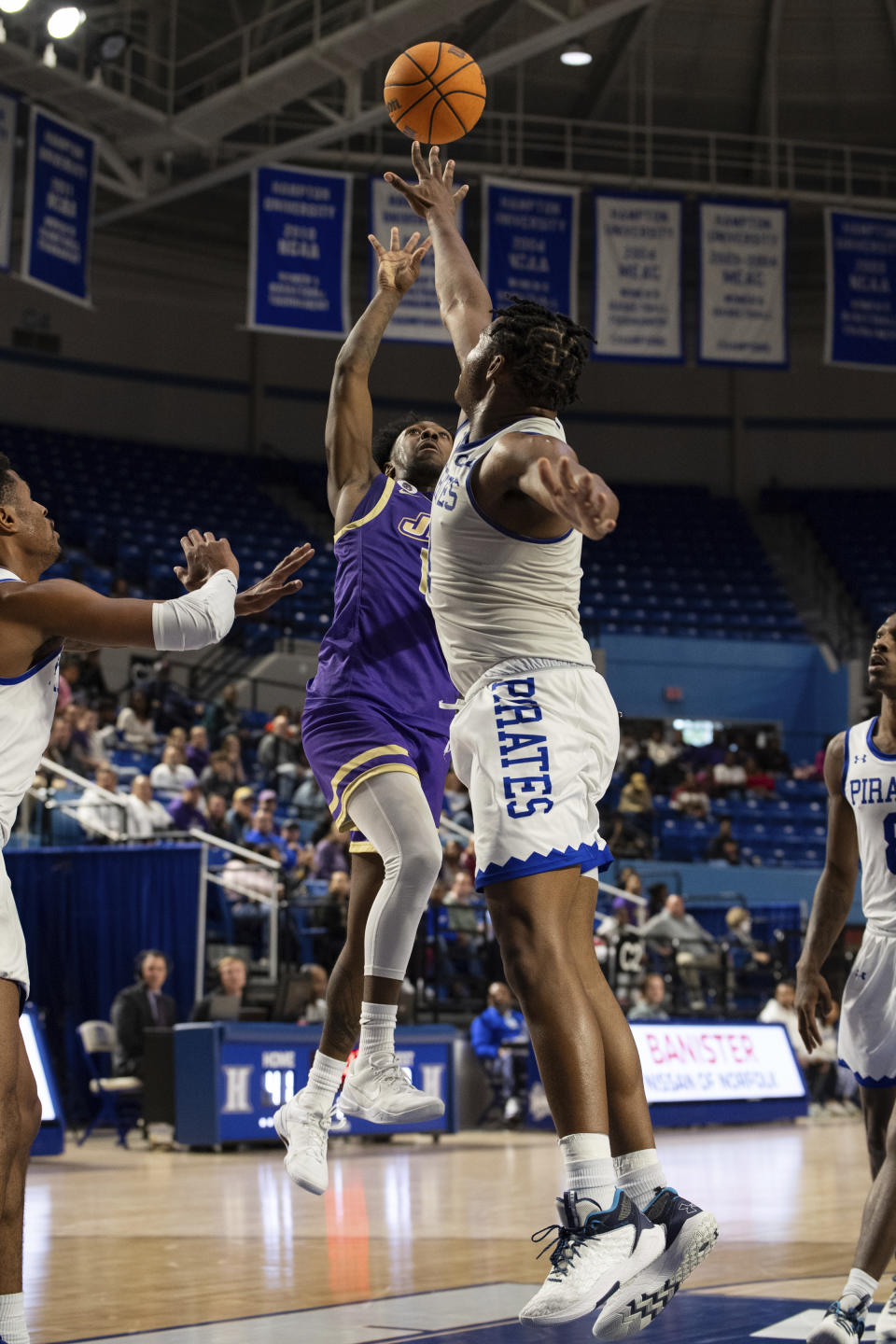 James Madison guard Michael Green III (13) attempts a shot over Hampton forward Kyrese Mullen (3) during the first half of an NCAA college basketball game Saturday, Dec. 16, 2023, in Hampton, Va. (AP Photo/Mike Caudill)