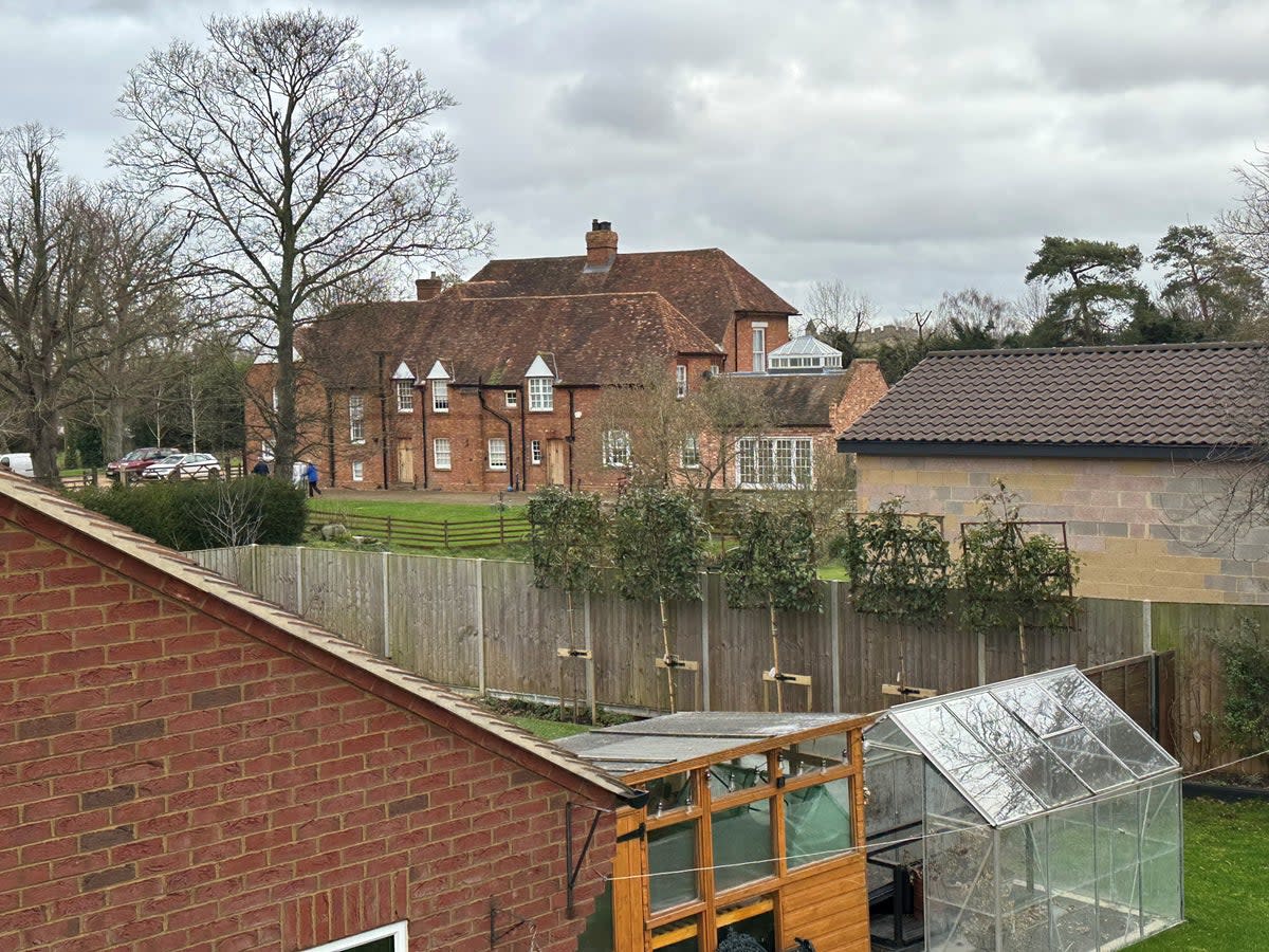 The view of the building (on the right) behind garden fences facing The Old Rectory (The Independent)