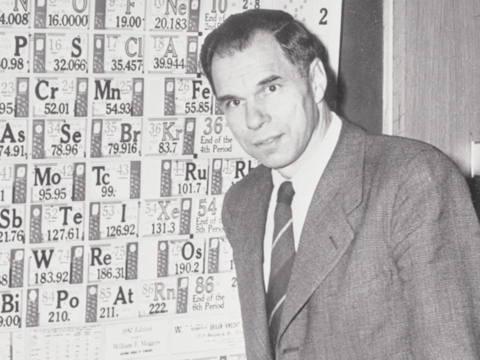 Nobel Prize winner Glenn Seaborg stands in front of a large periodic table of elements in 1951.