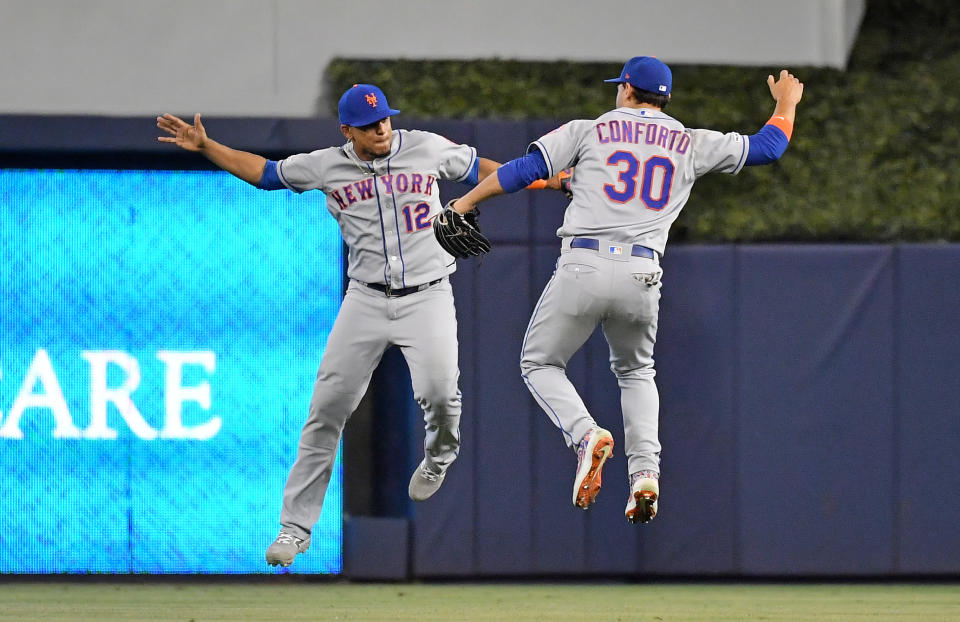 Jul 14, 2019; Miami, FL, USA; New York Mets center fielder Juan Lagares (12) and New York Mets right fielder Michael Conforto (30) celebrate after defeating the Miami Marlins at Marlins Park. Mandatory Credit: Jasen Vinlove-USA TODAY Sports