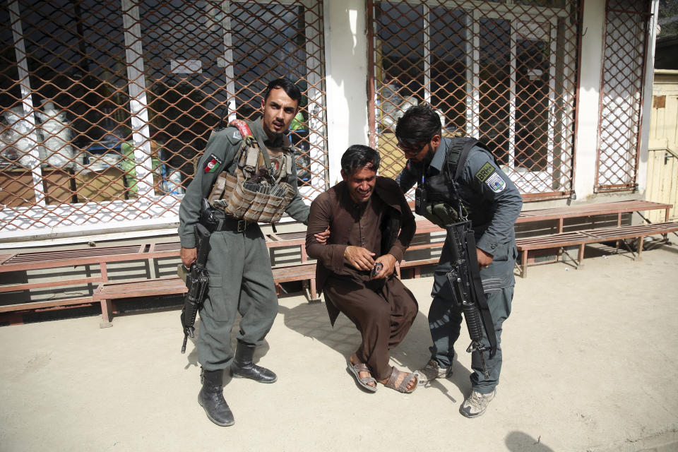 Afghan policemen comfort a man after an attack on a maternity hospital, in Kabul, Afghanistan, Tuesday, May 12, 2020. Militants stormed a maternity hospital in the western part of Kabul on Tuesday, setting off an hours-long shootout with the police and killing over a dozen people, including two newborn babies, their mothers and an unspecified number of nurses (AP Photo/Rahmat Gul)