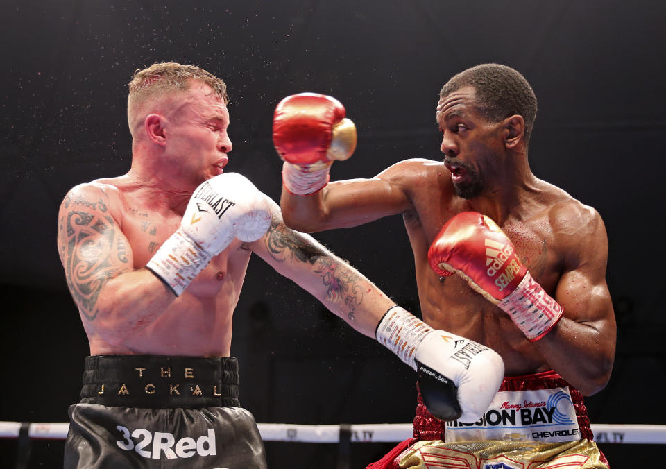 Jamel Herring of the United States, right, lands a blow on Britain's Carl Frampton during their WBO super-featherweight world title fight in Dubai, UAE, early Sunday April 4, 2021. (AP Photo/Kamran Jebreili)