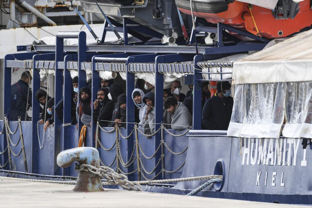 Migrants stand on the deck of the Humanity 1 rescue ship run by the German organization SOS Humanitarian, at harbor in the port of Catania, Sicily, southern Italy, Sunday, Nov. 6, 2022. The captain of the Humanity 1 refused Italian orders to leave a Sicilian port Sunday after authorities conducted a medical selection of the passengers and did not allow 35 to get off, acting under directives from Italy’s far-right-led government. (AP Photo/Salvatore Cavalli)