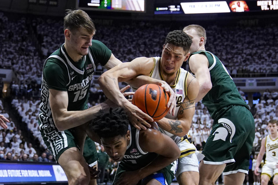 Purdue forward Mason Gillis (0) fights for a rebound with Michigan State center Carson Cooper (15) over guard A.J. Hoggard (11) during the second half of an NCAA college basketball game in West Lafayette, Ind., Sunday, Jan. 29, 2023. Purdue defeated Michigan State 77-61. (AP Photo/Michael Conroy)