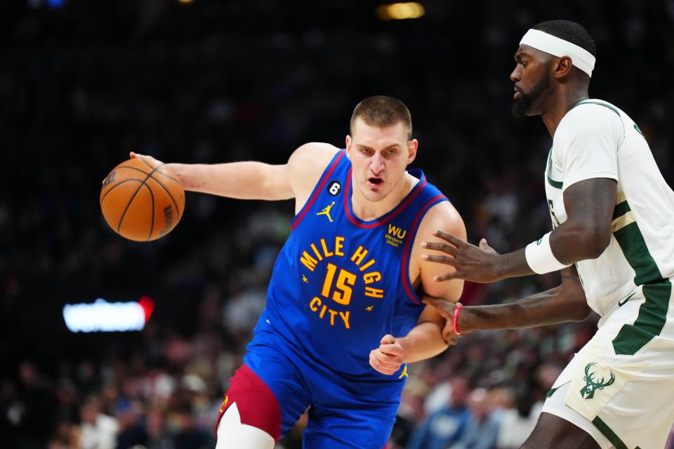 Denver Nuggets center Nikola Jokic (15) drives at Milwaukee Bucks forward Bobby Portis (9) during a game at Ball Arena.