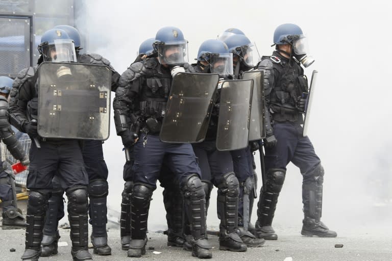 French riot police officers stand guard during a protest against the government's labour market reforms in Paris, on May 26, 2016