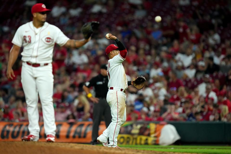 Cincinnati Reds second baseman Donovan Solano (7) throws the ball to the dugout that recorded Cincinnati Reds pitcher Fernando Cruz’s (63) first major-league strikeout during the sixth inning of a baseball game against the Colorado Rockies, Friday, Sept. 2, 2022, at Great American Ball Park in Cincinnati. 