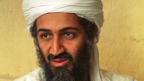 osama bin laden looks right of the camera, he wears a white turban and white top, he has a full mustache and long beard