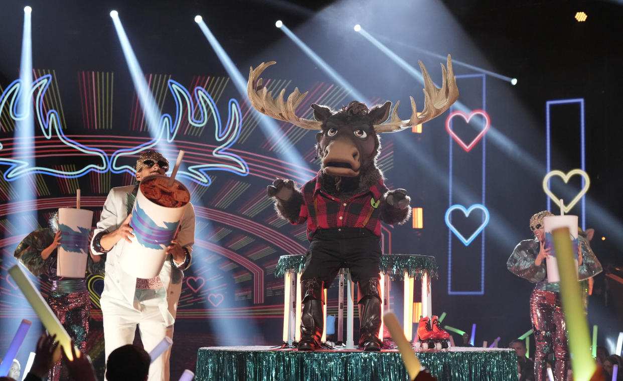 A person in a moose costume stands on stage as dancers run around him holding large sodas (Michael Becker / FOX)
