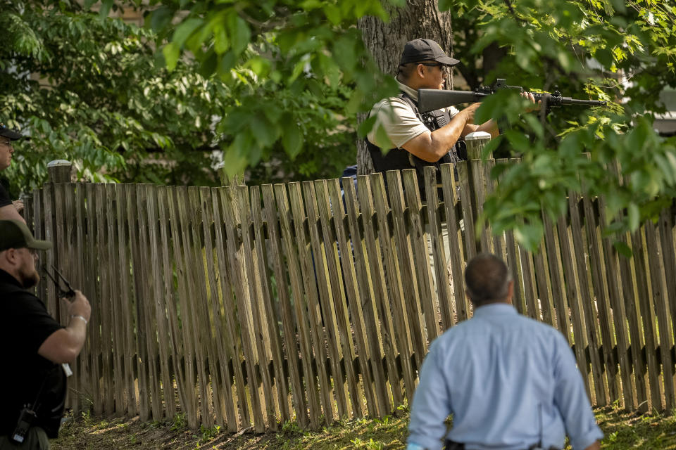 Officers move in to attempt to catch a black bear in the residential Brookland neighborhood in Northeast Washington, in Washington, Friday, June 9, 2023. The bear was eventually tranquilized by the Humane Rescue Alliance and taken away in a cage by the Smithsonian's National Zoo. (AP Photo/Andrew Harnik)