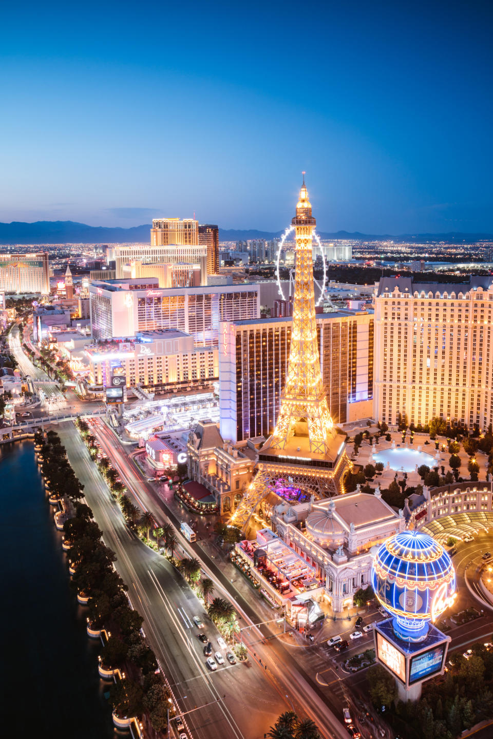 Aerial view of the Las Vegas Strip at night, showcasing illuminated hotels and a replica Eiffel Tower