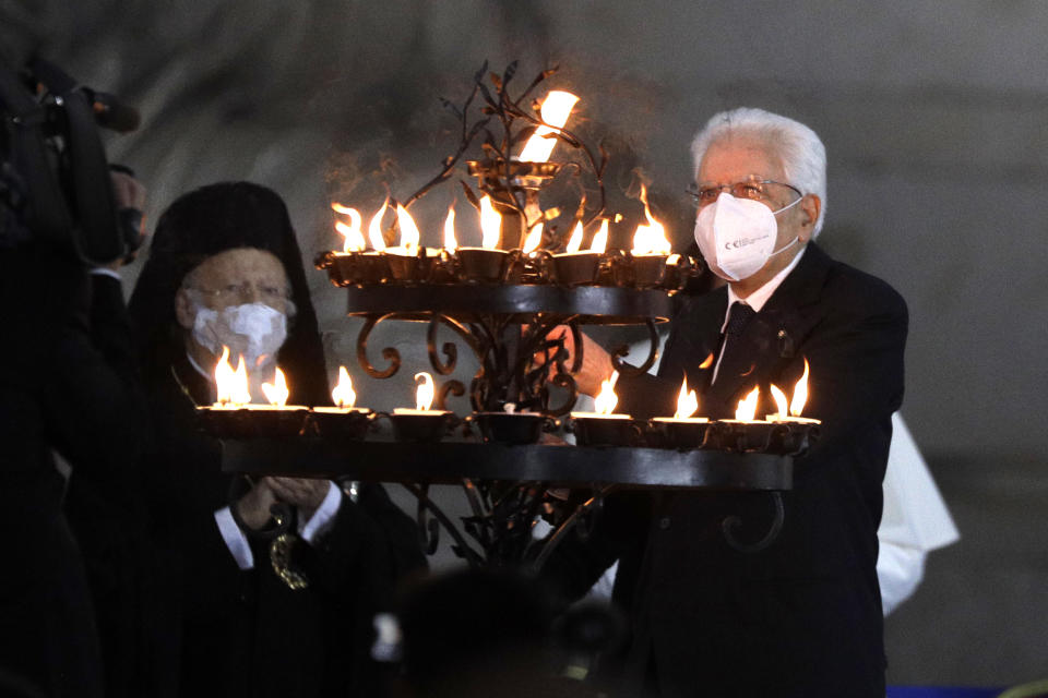 Italian President Sergio Mattarella lights a candle for peace during an inter-religious ceremony for peace in the square outside Rome's City Hall, Tuesday, Oct. 20, 2020 (AP Photo/Gregorio Borgia)