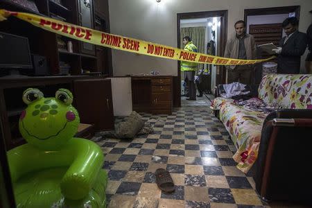 A member of the crime scene investigation unit takes notes as he stands beside the owners of a home that was robbed in Lahore January 13, 2015. REUTERS/Zohra Bensemra