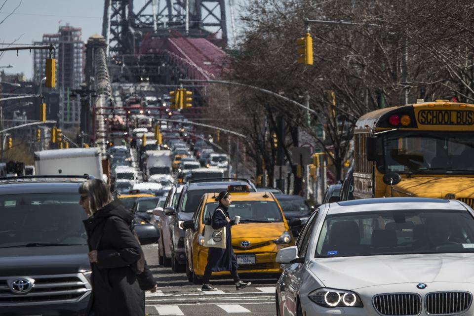 FILE - Pedestrians cross Delancey Street as congested traffic from Brooklyn enters Manhattan over the Williamsburg Bridge, March 28, 2019, in New York. Roadway deaths rose 7% during the first three months of 2022 to 9,560 people, the highest number for a first quarter in two decades, according to estimates by the National Highway Traffic Safety Administration. (AP Photo/Mary Altaffer, File)