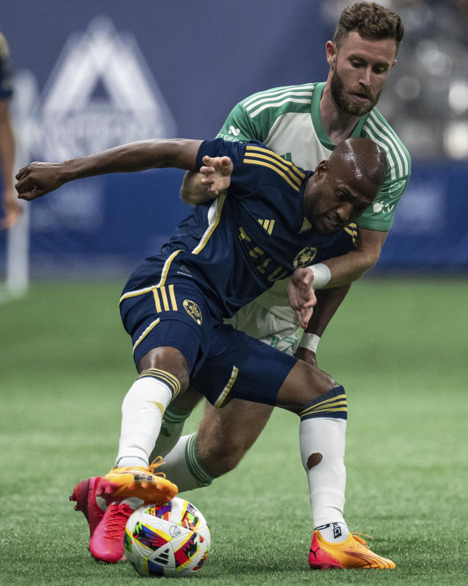Vancouver Whitecaps' Fafa Picault, front, and Austin FC's Jon Gallagher (17) vie for the ball during the first half of an MLS soccer match in Vancouver, British Columbia, on Saturday, May 4, 2024. (Ethan Cairns/The Canadian Press via AP)