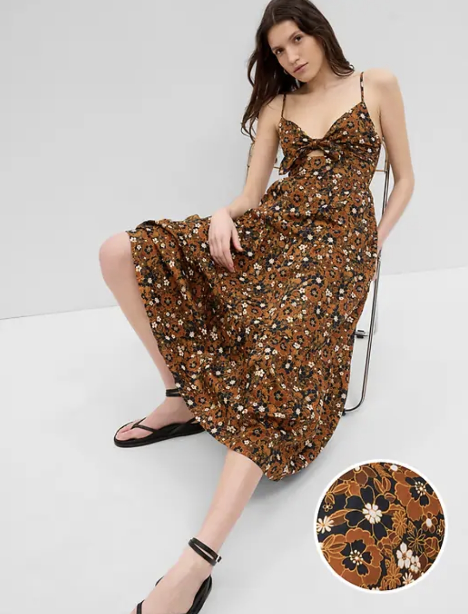 brunette model sitting on chair wearing Tie-Front Cutout Maxi Dress in Brown Floral (photo via Gap)